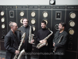 Saxophone quartet smiling holding vintage saxophones
