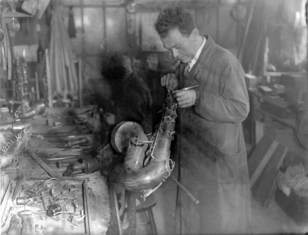 A factory worker assembling a saxophone.